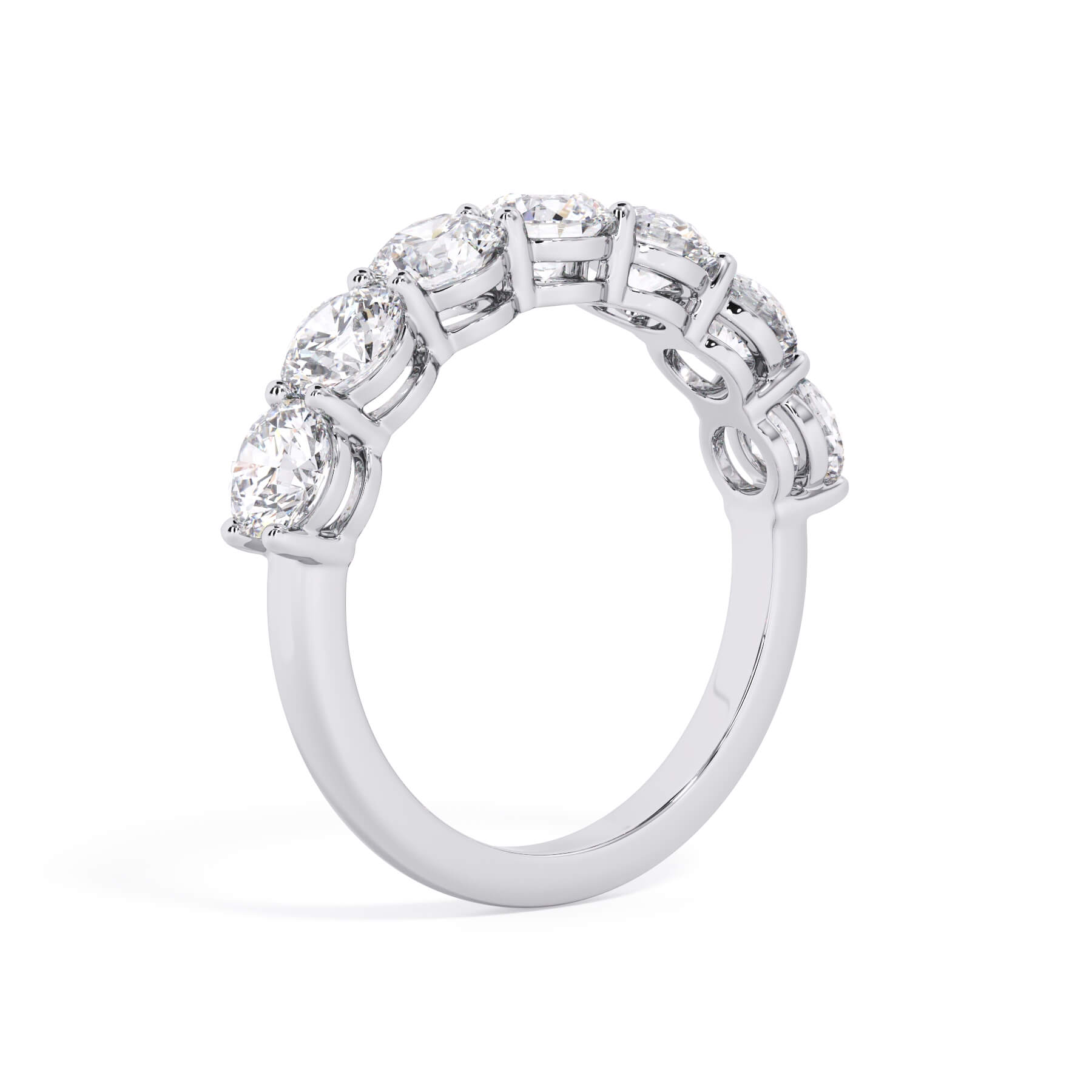 A picture of a seven stone diamond wedding ring with round diamonds that are shared prong set in white gold or platinum on a white background with a slightly angled, through the finger view.