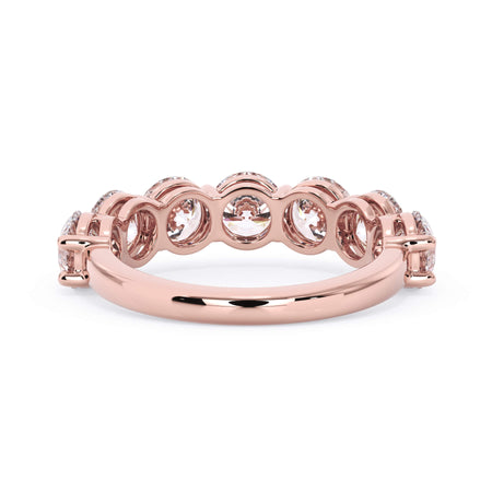 A picture of a seven stone diamond wedding ring with round diamonds that are shared prong set in rose gold on a white background with a view of the underside of the ring.