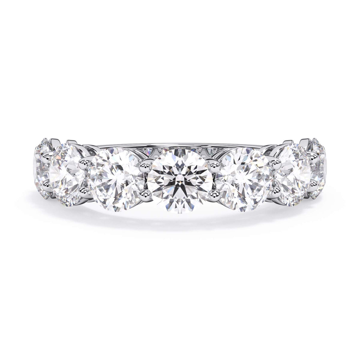 A picture of a seven stone diamond wedding ring with round diamonds that are shared prong set in white gold or platinum on a white background with the ring facing forward, lying down.