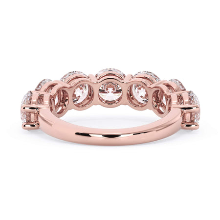 A picture of a seven stone diamond wedding ring with round diamonds that are shared prong set in rose gold on a white background with a view of the underside of the ring.
