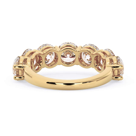A picture of a seven stone diamond wedding ring with round diamonds that are shared prong set in yellow gold on a white background with a view of the underside of the ring.