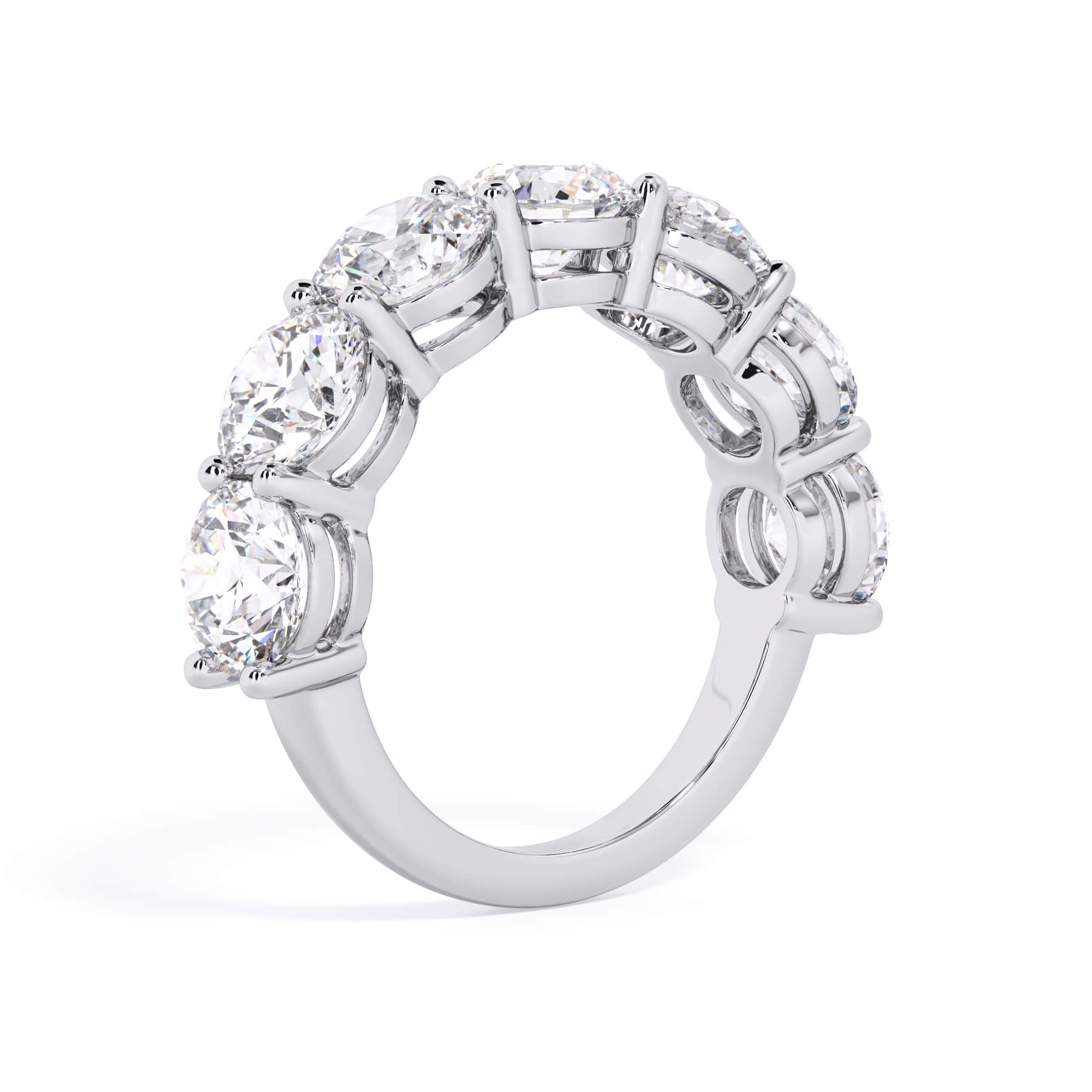A picture of a seven stone diamond wedding ring with round diamonds that are shared prong set in white gold or platinum on a white background with a slightly angled, through the finger view.
