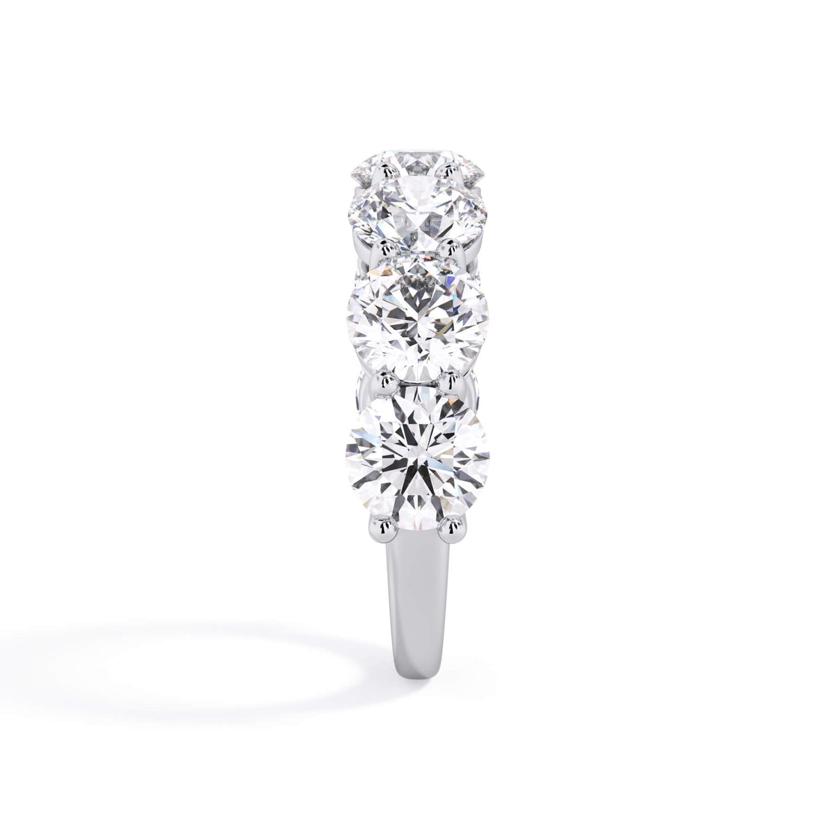 A picture of a seven stone diamond wedding ring with round diamonds that are shared prong set in white gold or platinum on a white background with a side profile view.