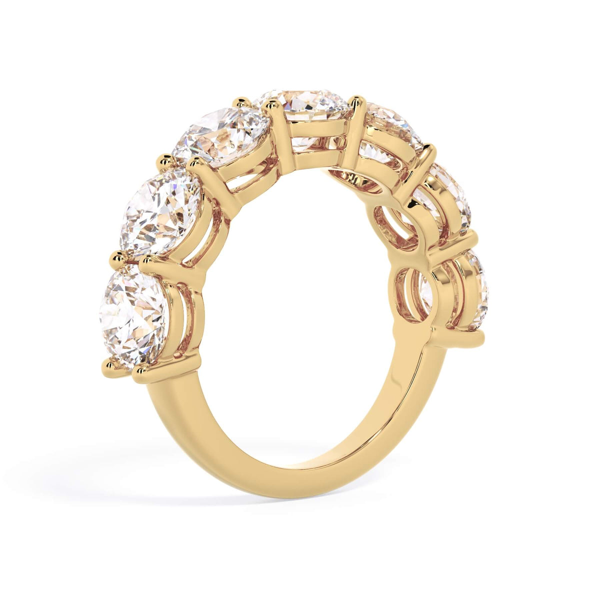 A picture of a seven stone diamond wedding ring with round diamonds that are shared prong set in yellow gold on a white background with a slightly angled, through the finger view.
