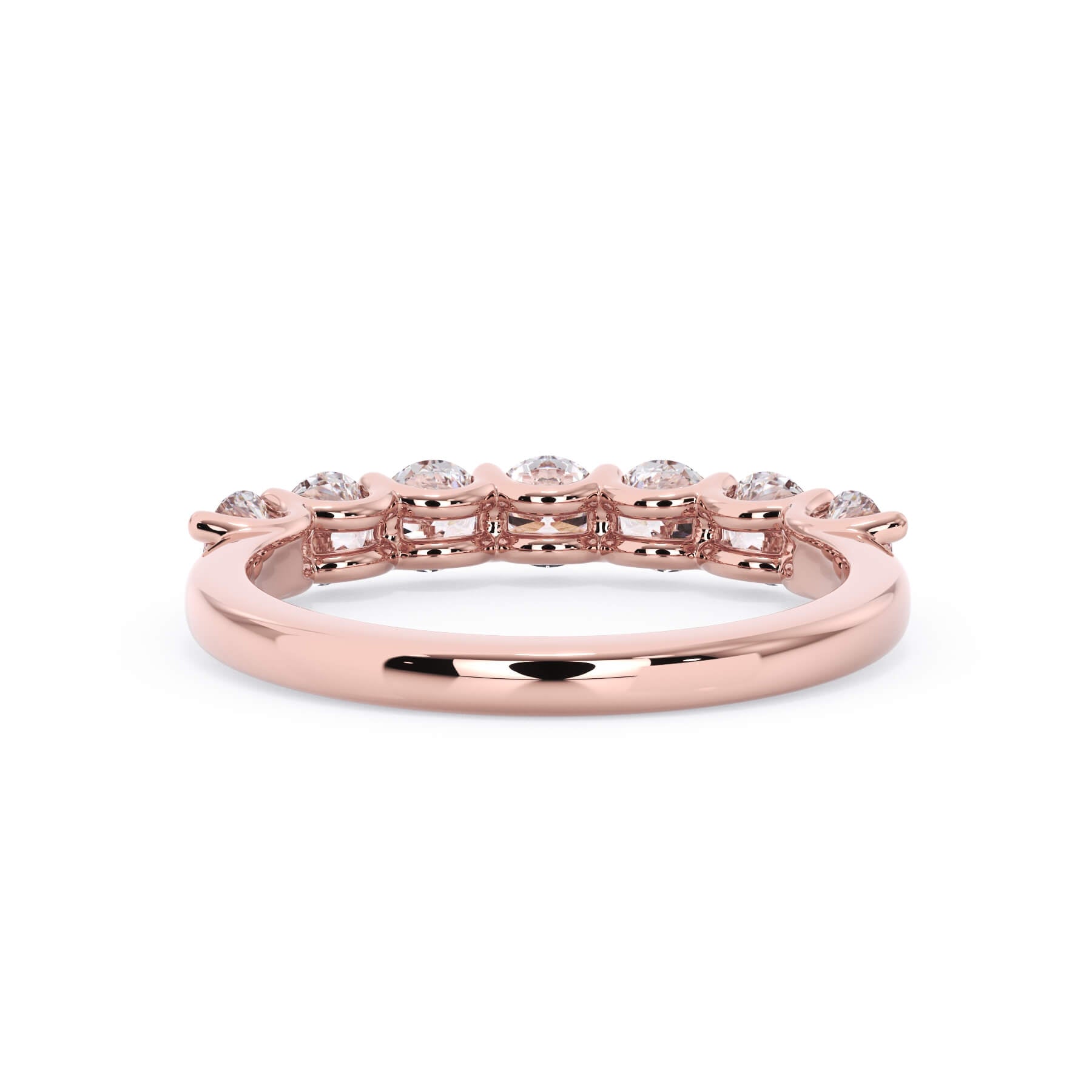 A picture of a seven stone diamond wedding ring with round diamonds that are U prong set in rose gold on a white background with a view of the underside of the ring.