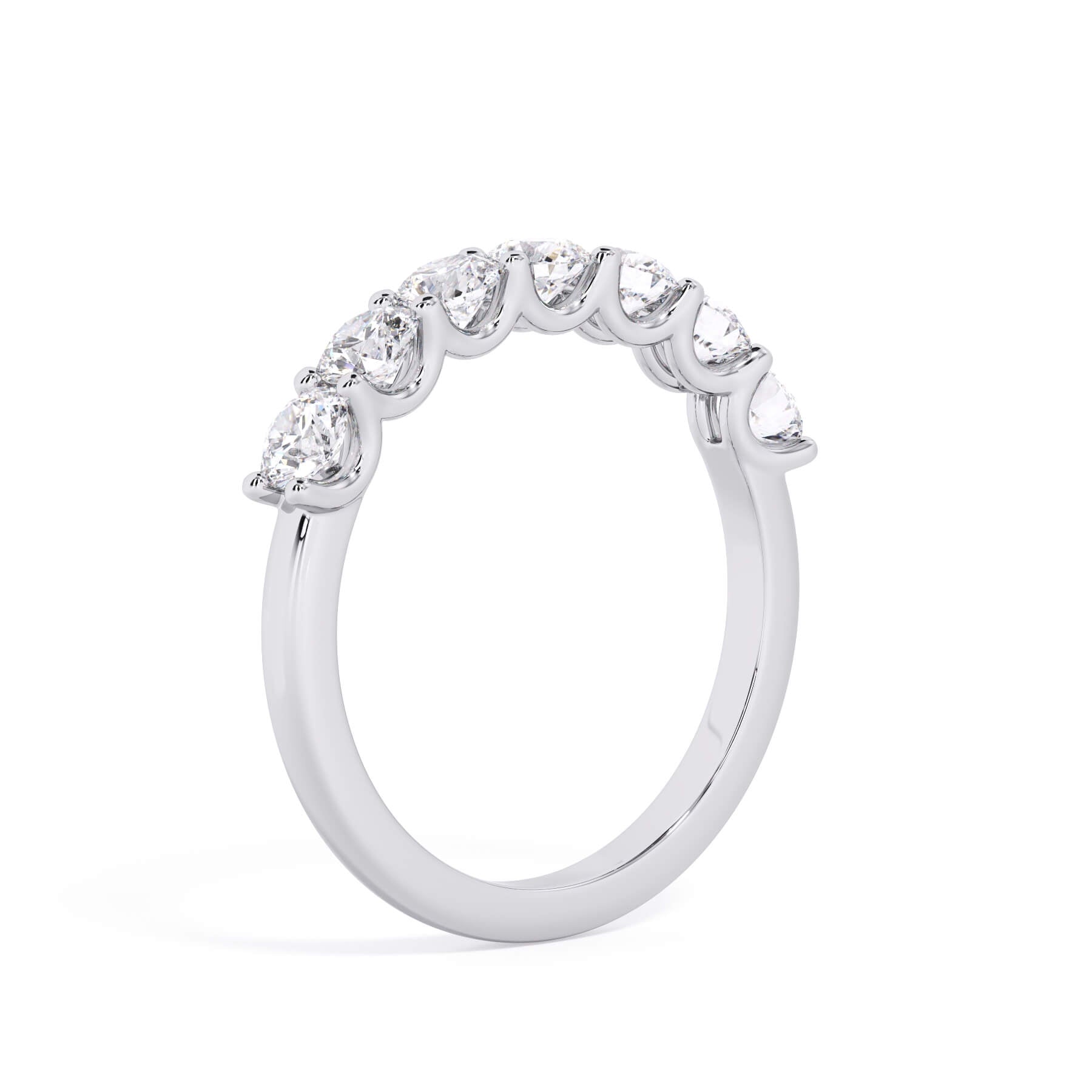 A picture of a seven stone diamond wedding ring with round diamonds that are U prong set in white gold or platinum on a white background with a slightly angled, through the finger view.