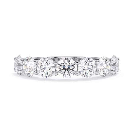 A picture of a seven stone diamond wedding ring with round diamonds that are U prong set in white gold or platinum on a white background with the ring facing forward, lying down.