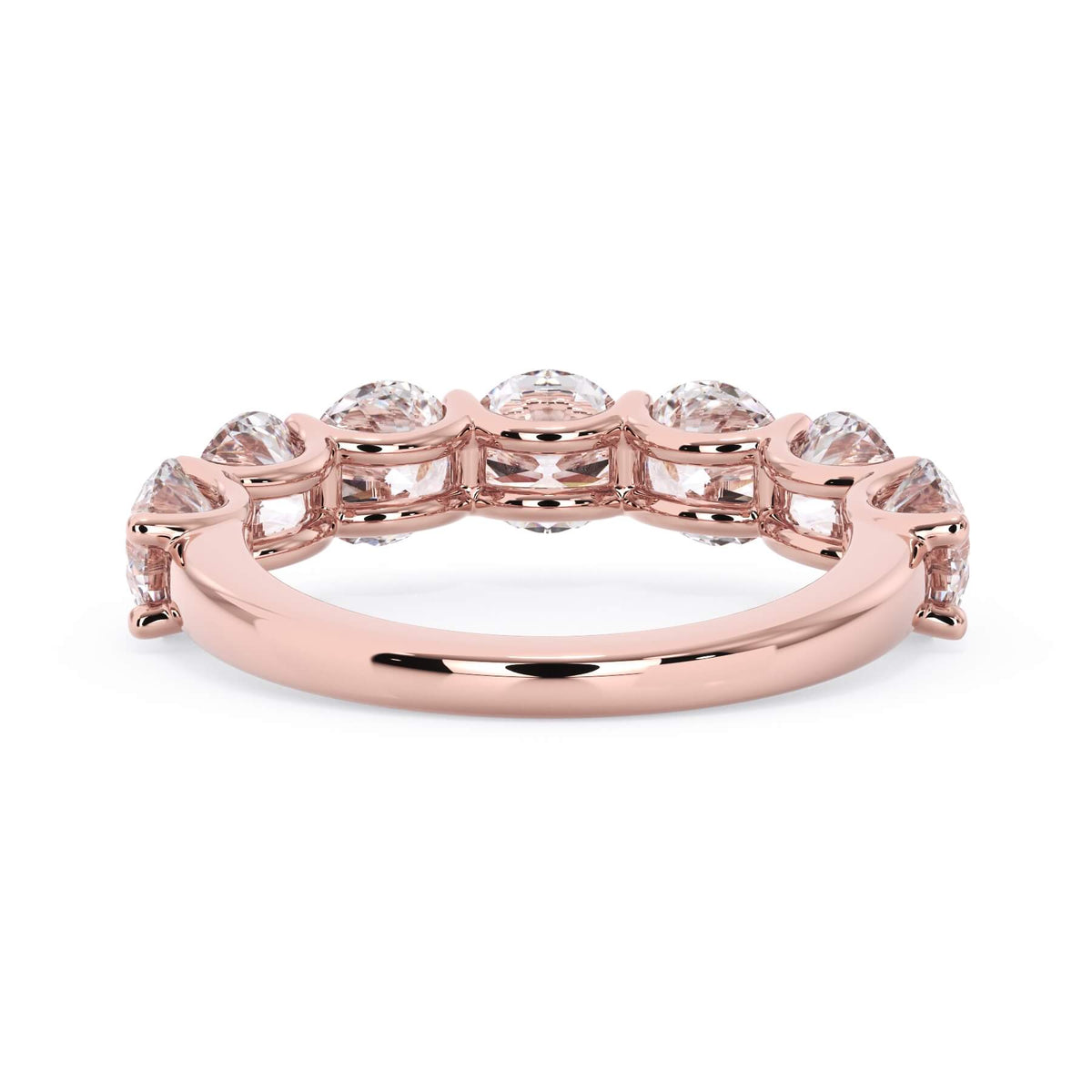 A picture of a seven stone diamond wedding ring with round diamonds that are U prong set in rose gold on a white background with a view of the underside of the ring.
