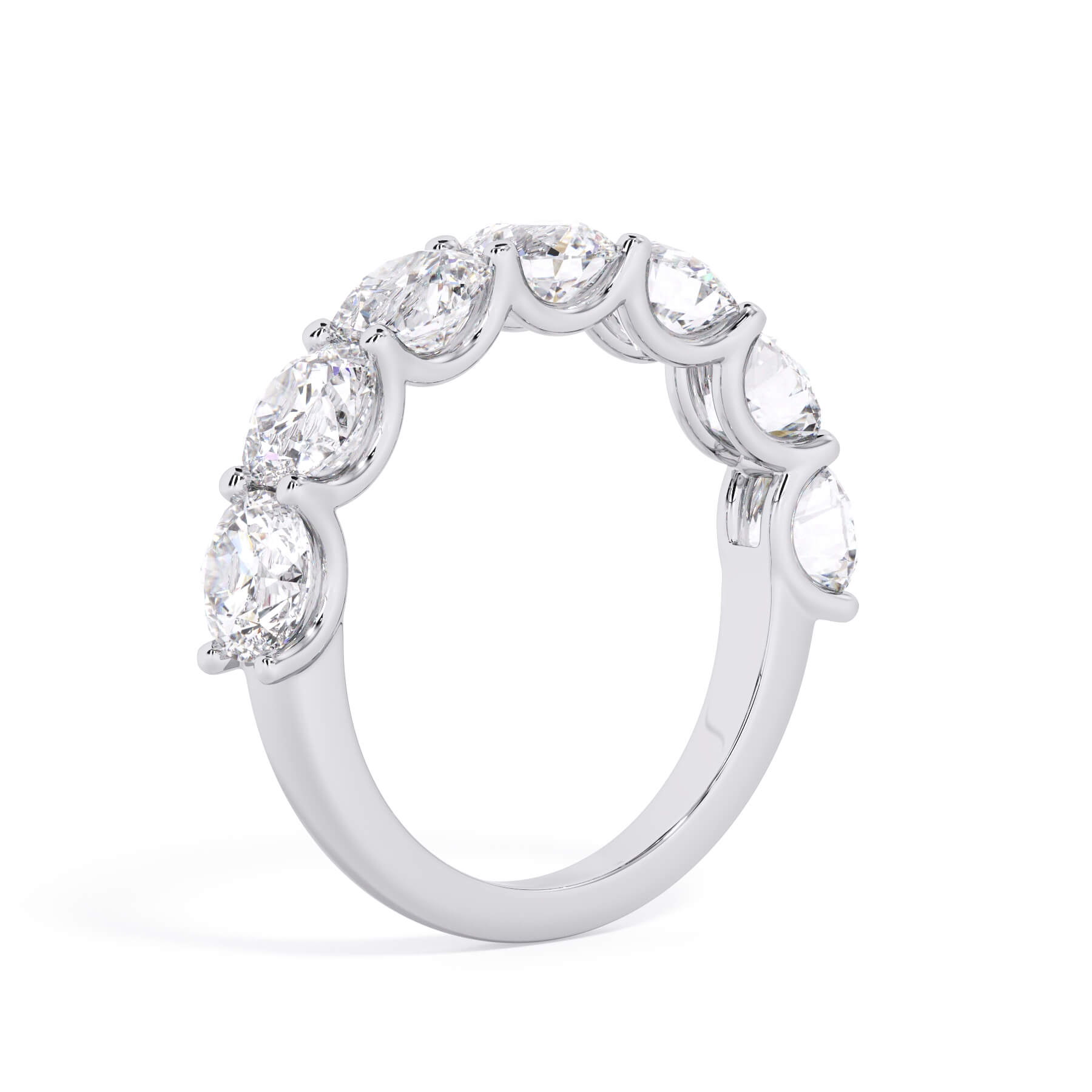 A picture of a seven stone diamond wedding ring with round diamonds that are U prong set in white gold or platinum on a white background with a slightly angled, through the finger view.