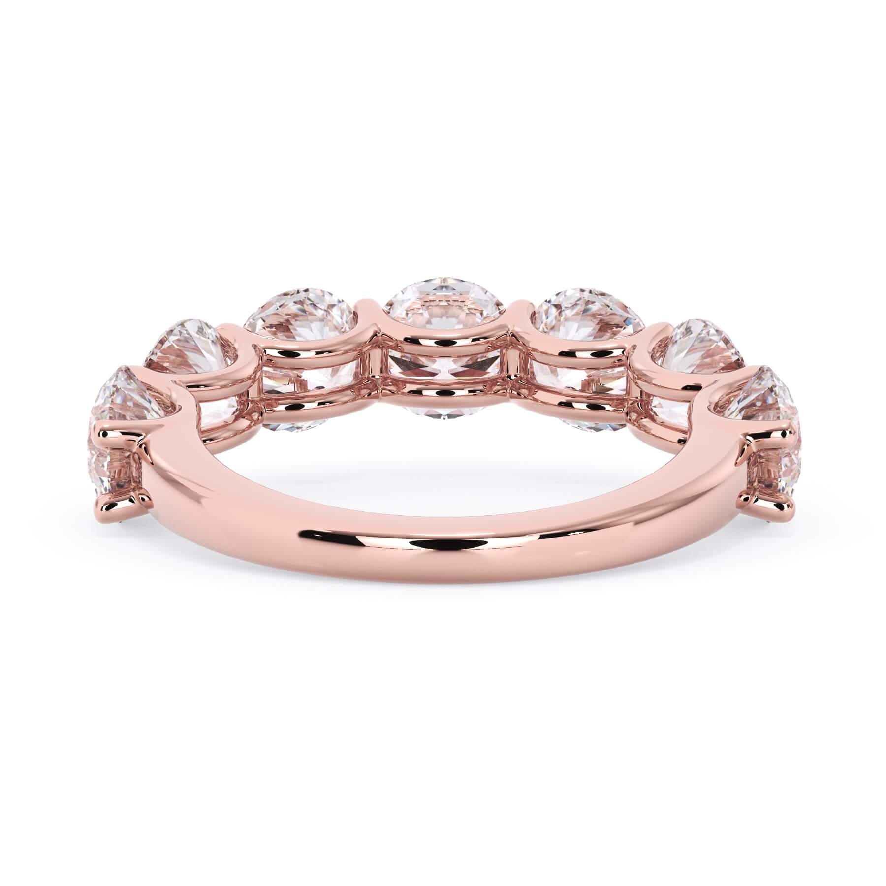 A picture of a seven stone diamond wedding ring with round diamonds that are U prong set in rose gold on a white background with a view of the underside of the ring.