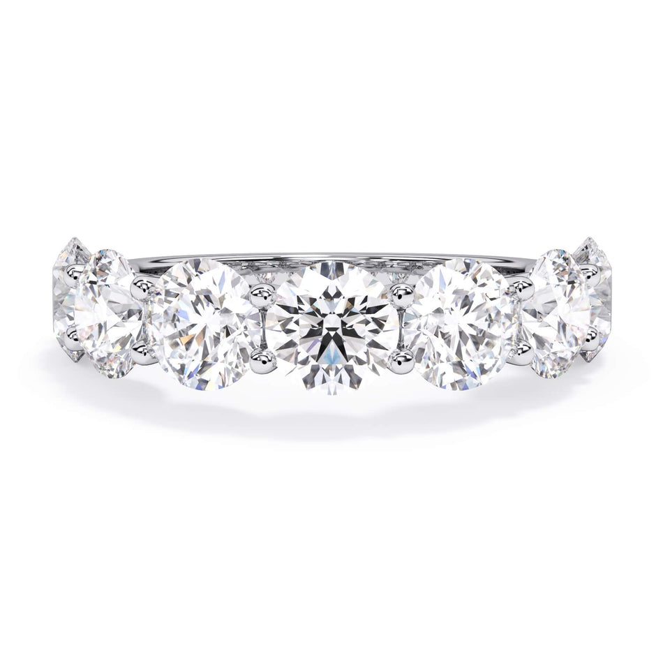 A picture of a seven stone diamond wedding ring with round diamonds that are U prong set in white gold or platinum on a white background with the ring facing forward, lying down.