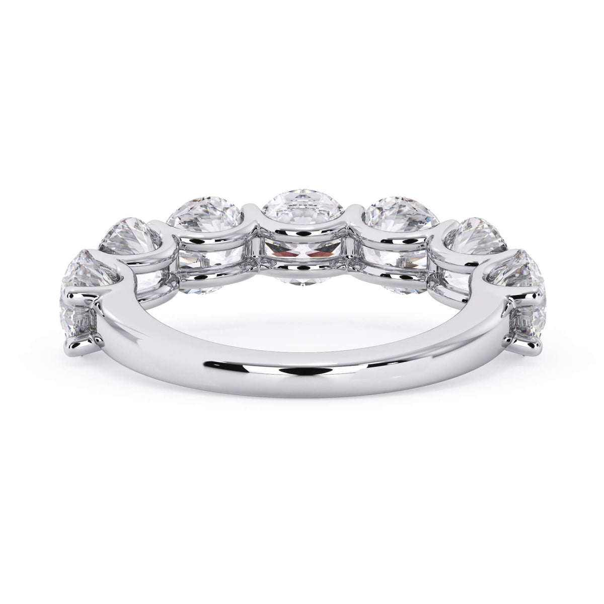 A picture of a seven stone diamond wedding ring with round diamonds that are U prong set in white gold or platinum on a white background with a view of the underside of the ring.