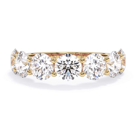A picture of a seven stone diamond wedding ring with round diamonds that are U prong set in yellow gold on a white background with the ring facing forward, lying down.