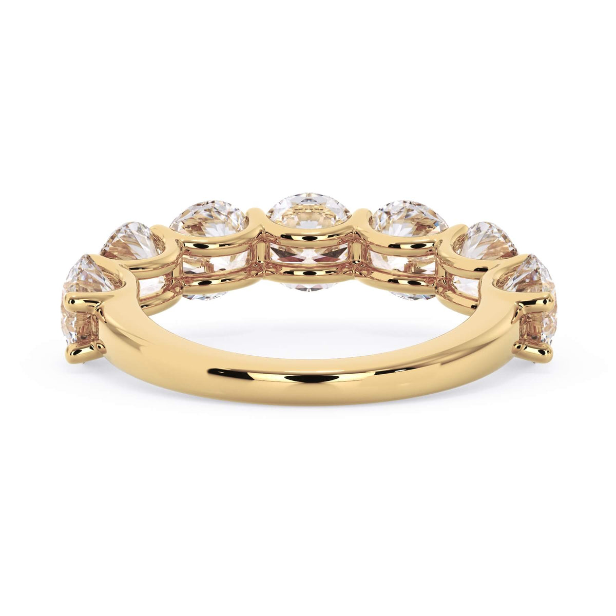A picture of a seven stone diamond wedding ring with round diamonds that are U prong set in yellow gold on a white background with a view of the underside of the ring.