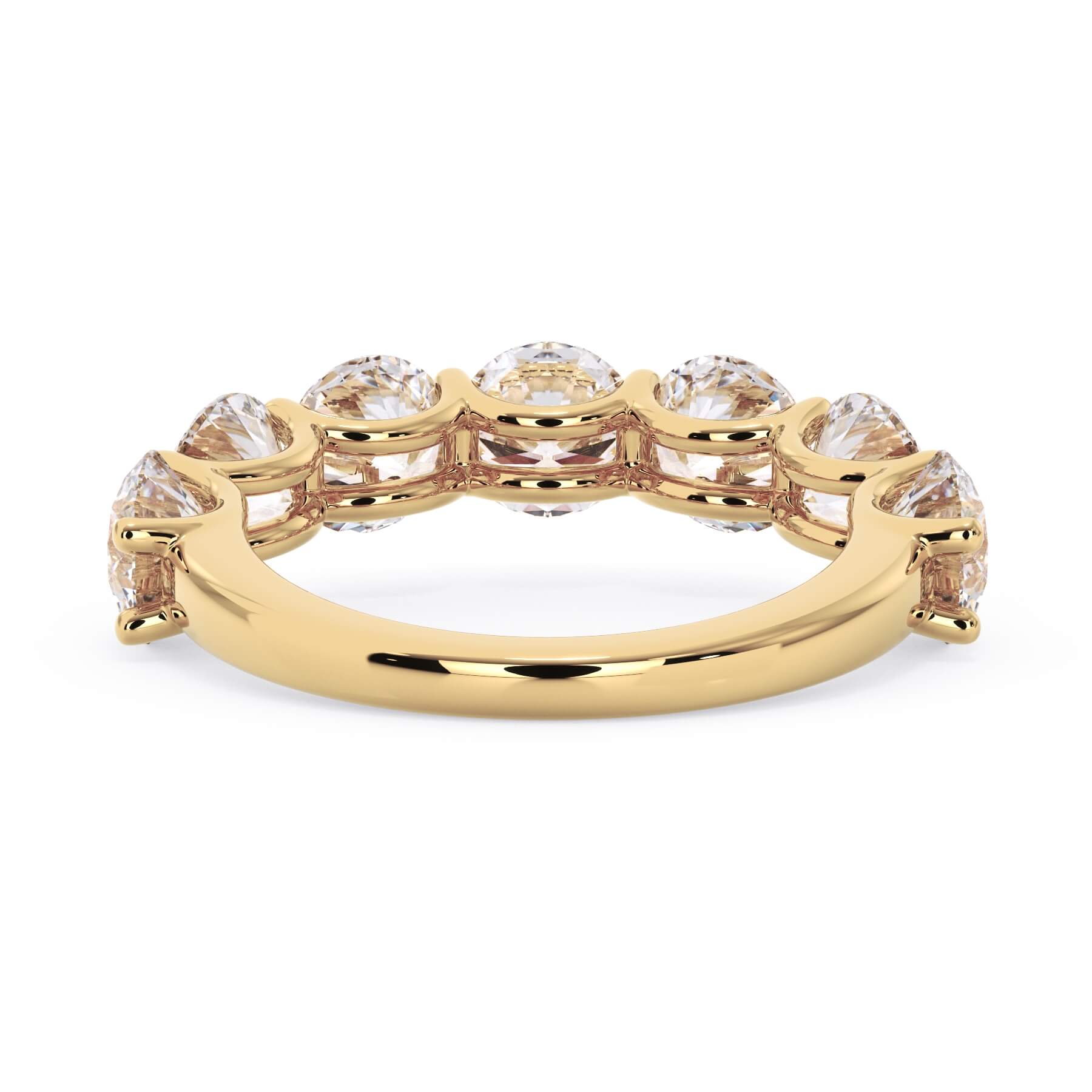 A picture of a seven stone diamond wedding ring with round diamonds that are U prong set in yellow gold on a white background with a view of the underside of the ring.