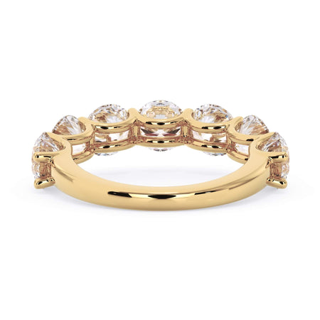 A picture of a seven stone diamond wedding ring with round diamonds that are U prong set in yellow gold on a white background with a view of the underside of the ring.