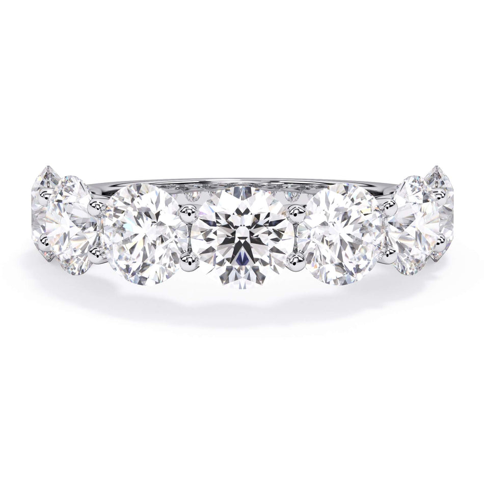 A picture of a seven stone diamond wedding ring with round diamonds that are U prong set in white gold or platinum on a white background with the ring facing forward, lying down.