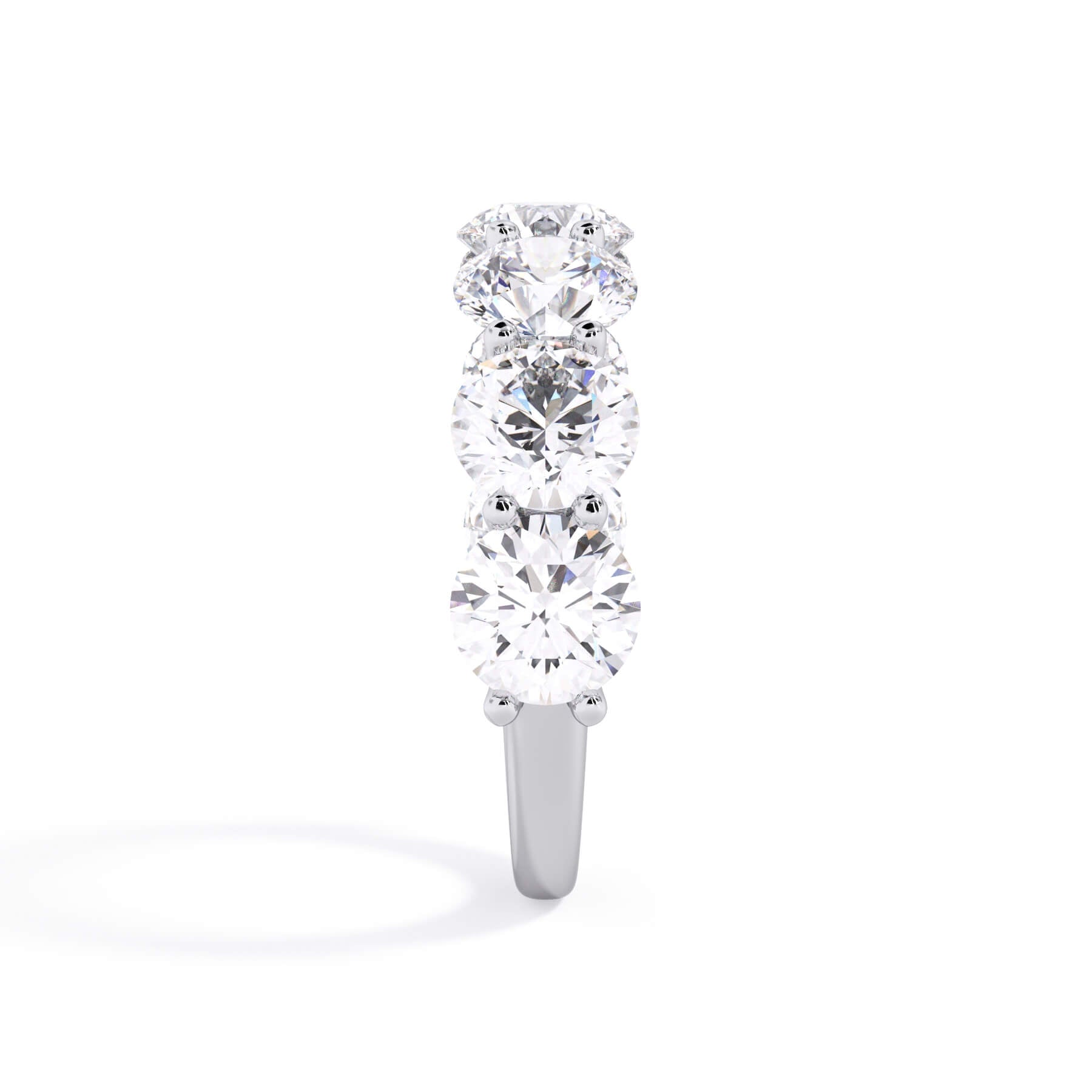 A picture of a seven stone diamond wedding ring with round diamonds that are U prong set in white gold or platinum on a white background with a side profile view.