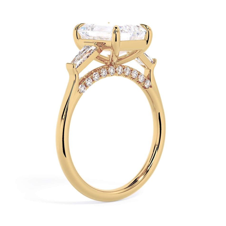 Three Stone Cathedral Diamond Setting (SKU: HE-518) Shown with Emerald Shape Diamond in Yellow Gold  - Through the Finger View